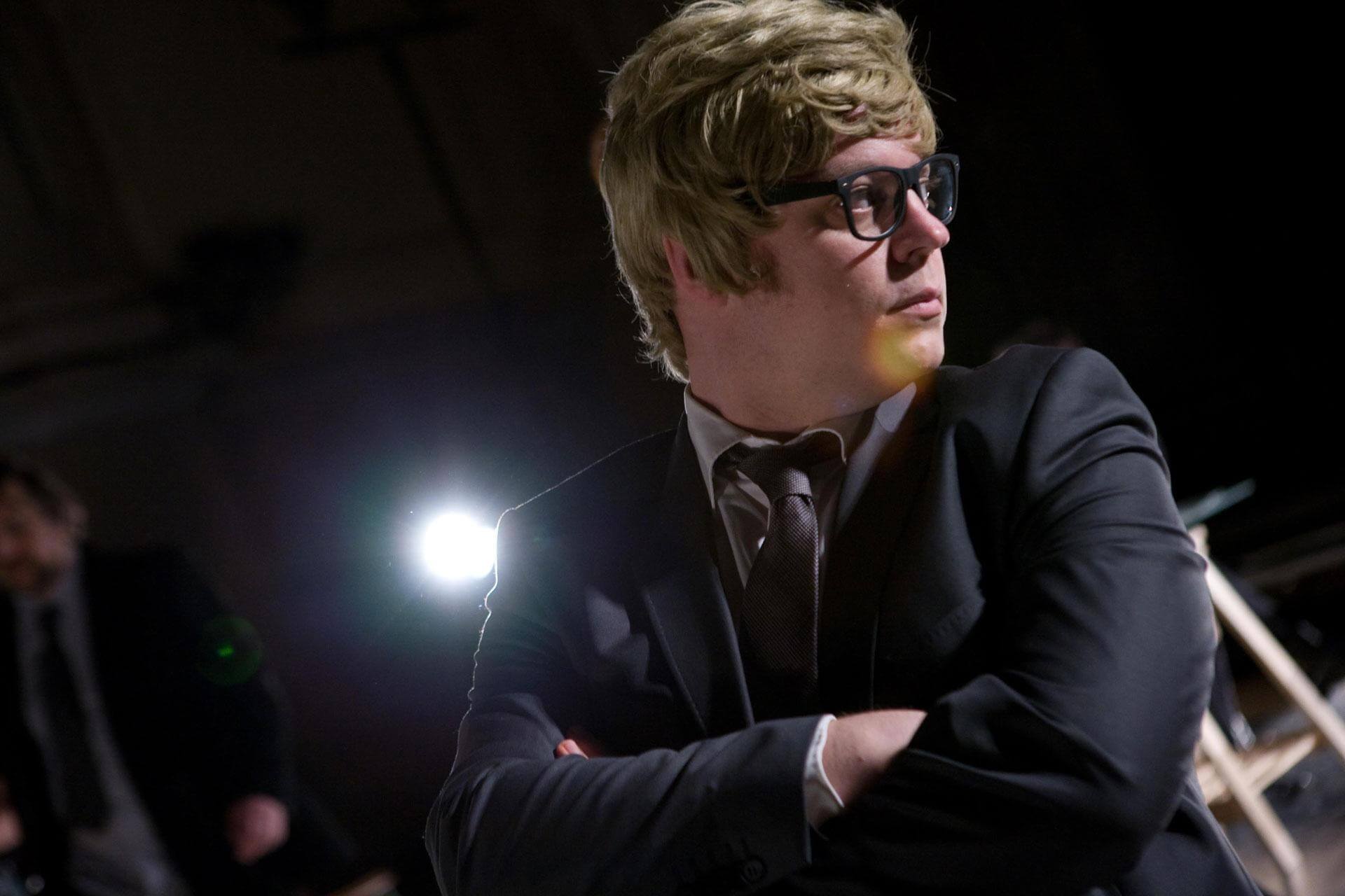 Le manager en costume sombre, lunettes, bras croisés