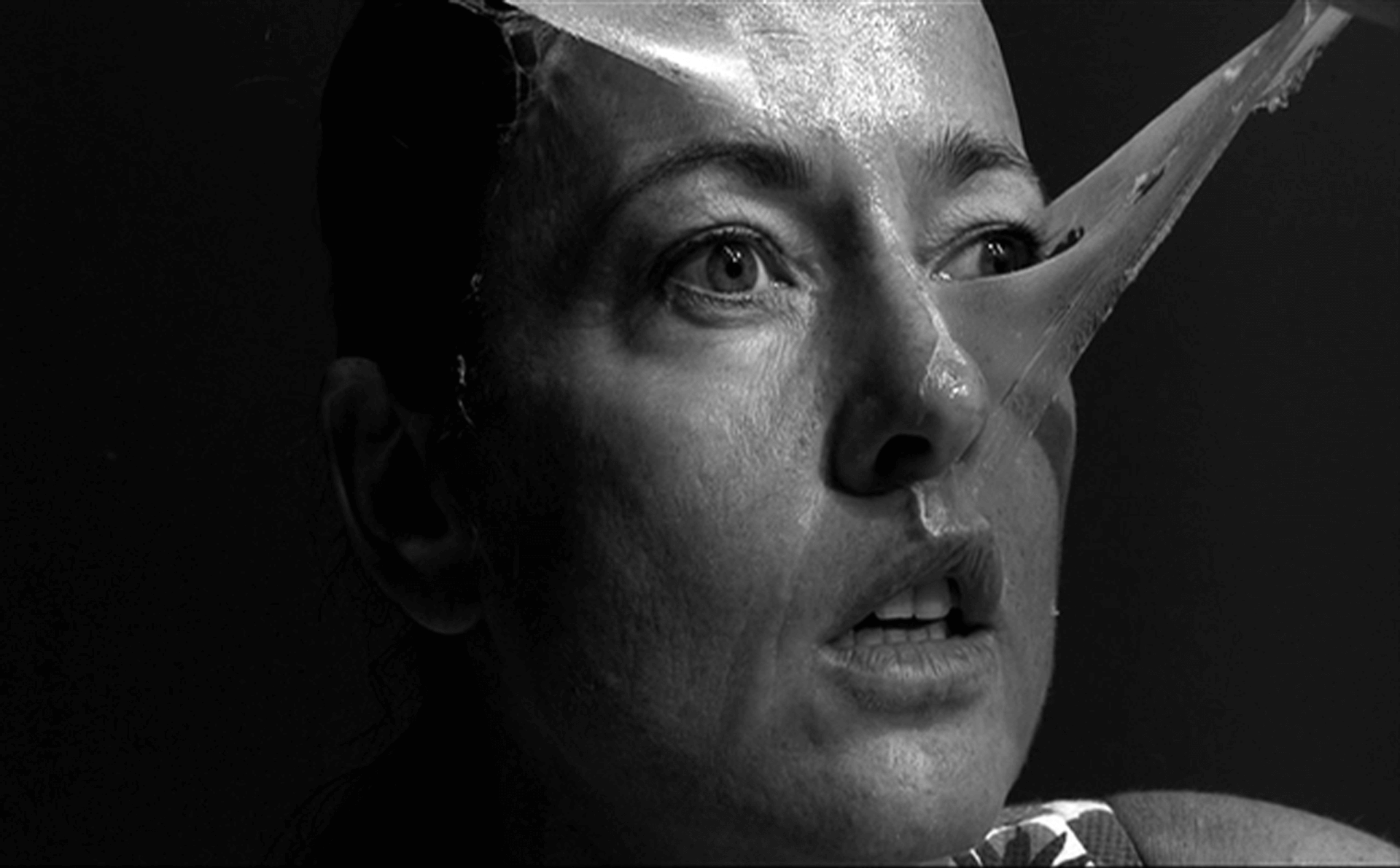 Gros plan en noir et blanc, un visage sous un film plastique