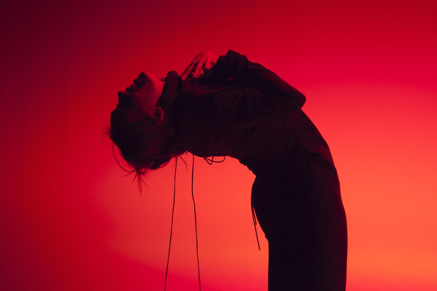 Photographies de A — silhouette rouge cambrée, création Cie Les Blouses Bleues, théâtre Daniel Keene