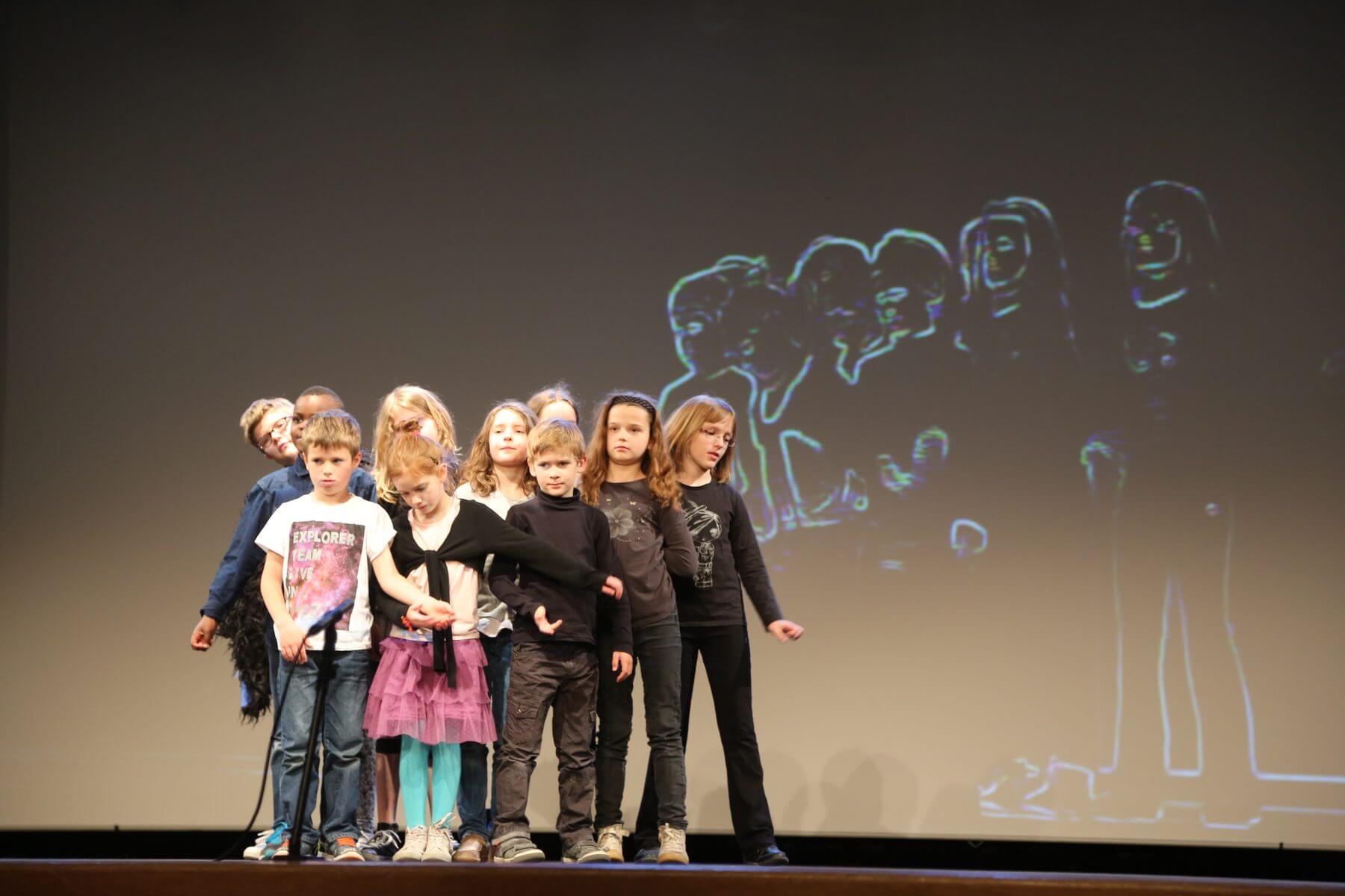 Les enfants de l atelier theatre d Hellemmes en mouvement sur le plateau du Kursaal, devant une projection video
