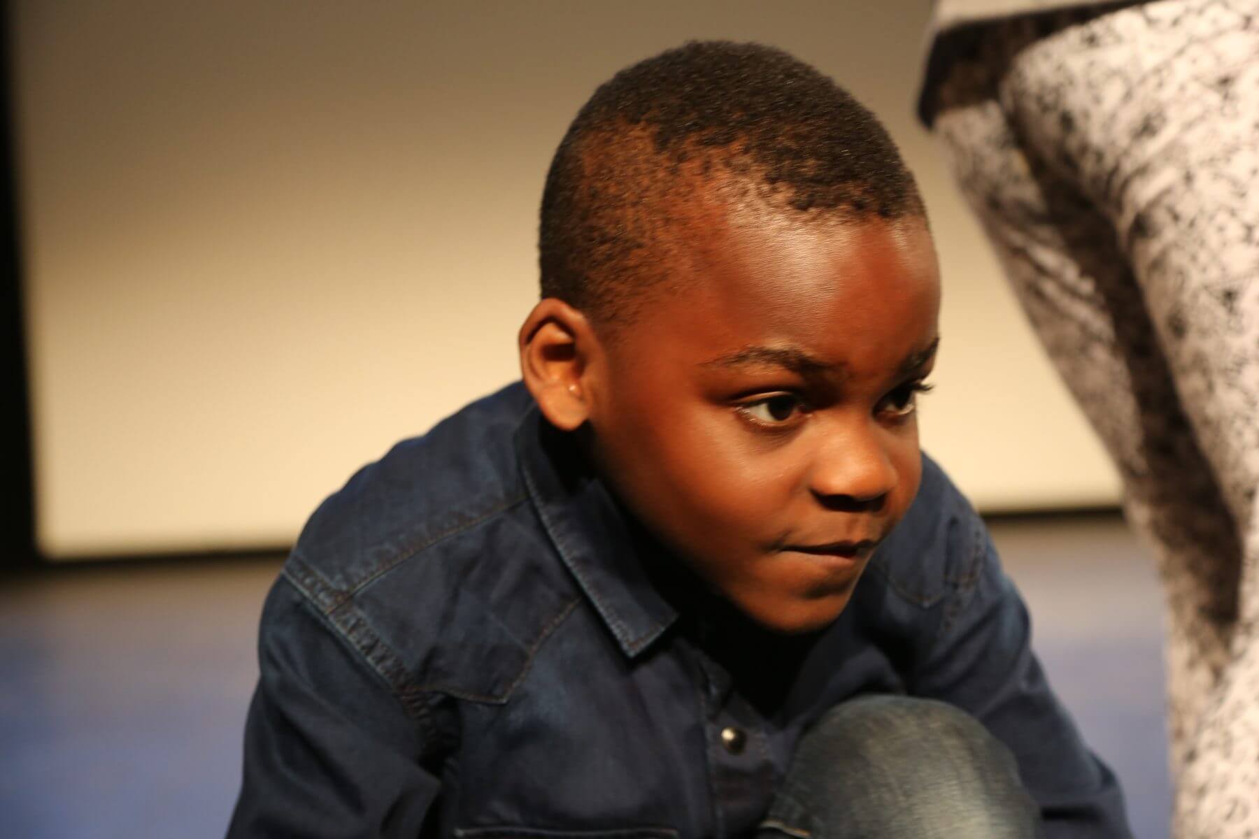 Portrait d un jeune comedien en chemise en jean, concentre sur le plateau