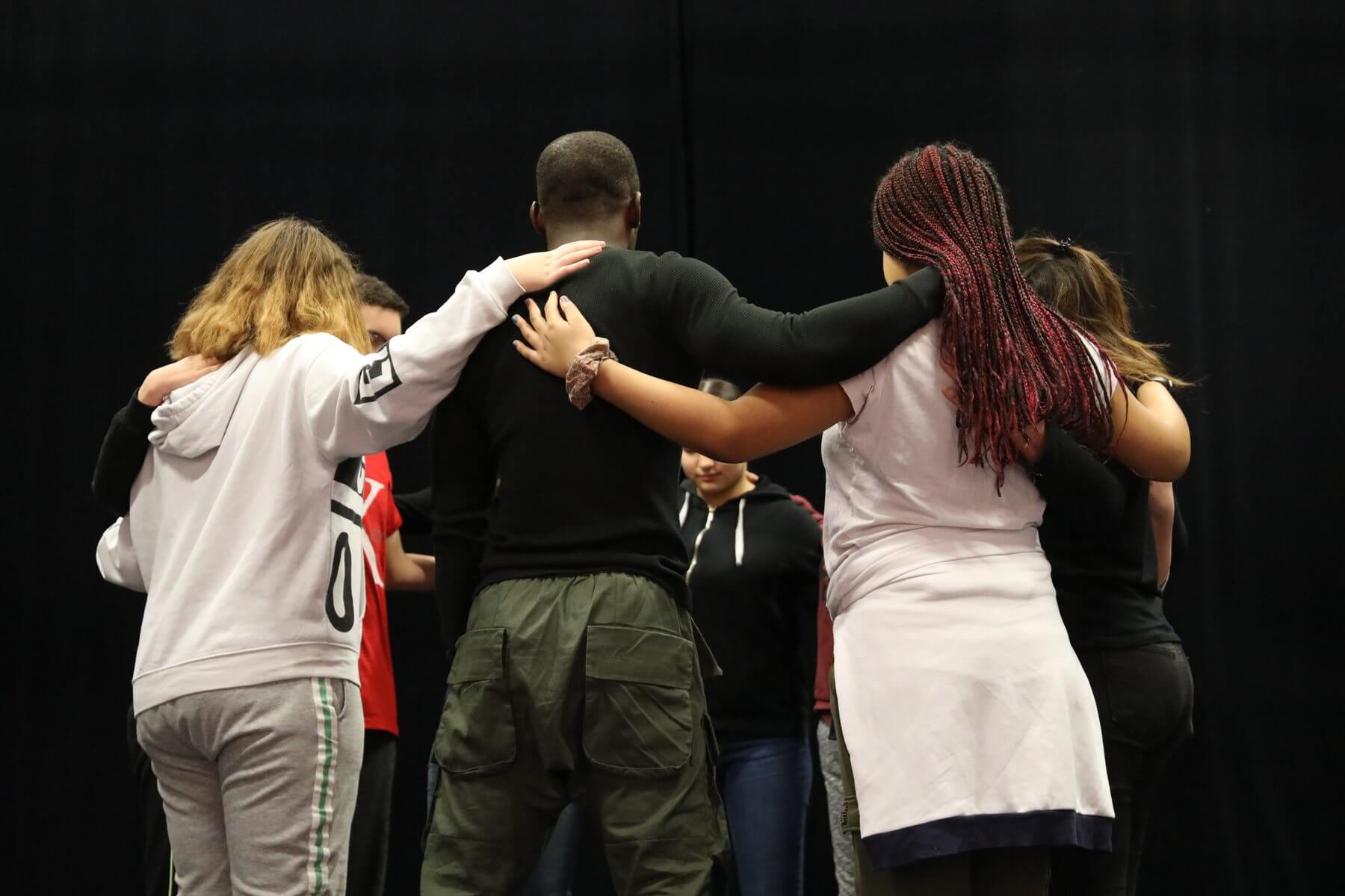 Les adolescents de l atelier theatre d Hellemmes en cercle sur le plateau, mains sur les epaules, pendant un exercice de groupe
